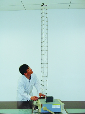這是伸展開(kāi)的衛(wèi)星太陽(yáng)能電池用盤壓伸桿，20厘米長(zhǎng)螺旋狀的盤壓伸桿（右側(cè)小圖）打開(kāi)后能達(dá)2米長(zhǎng)（8月7日攝）。（新華社發(fā)）