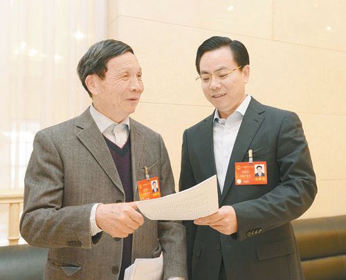 黃伯云代表（左）與劉國忠代表商討完善《關(guān)于建立戰(zhàn)略性新興產(chǎn)業(yè)國家創(chuàng)新平臺》的建議。 本報記者 張目 攝